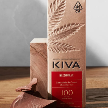 "High Dose Milk Chocolate bar with a silky finish on a rustic wooden table."